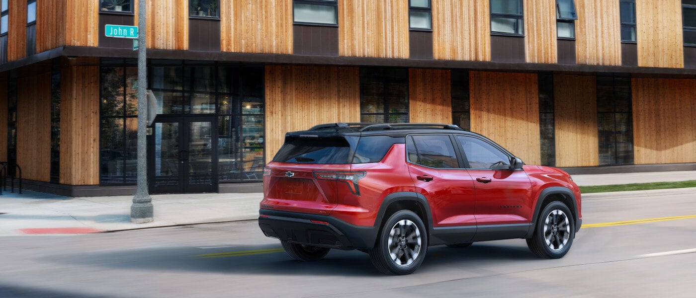 2027 Chevy Equinox driving past wooden office building